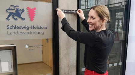 Bevollmächtigte des Landes Schleswig-Holstein beim Bund Staatssekretärin Sandra Gerken klebt den Segensspruch der Sternsinger an die Tür 