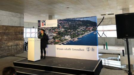 Finanzministerin Monika Heinold spricht im Rohbau vor Plakatwand