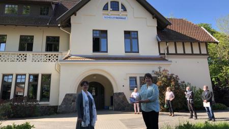 Finanzministerin Monika Heinold mit Geschäftsführerin Andrea Freytag vor dem Schulgebäude