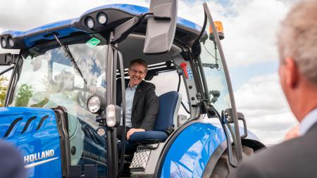 Ein Mann sitzt am Steuer eines blauen Traktors