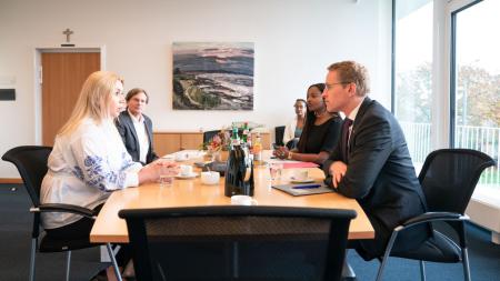 Ministerpräsident Günther und Integrationsministerin Touré sitzen mit der ukrainischen Generalkonsulin Tybinka an einem Tisch und unterhalten sich