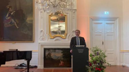 Ministerpräsident Daniel Günther steht an einem Rednerpult, das im Saal eines Schlosses steht.