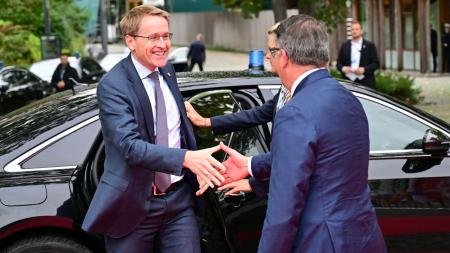 Ministerpräsident Daniel Günther steigt aus einem Auto aus und reicht dem Ministerpräsidenten von Hessen, Boris Rhein, lächelnd die Hand. 