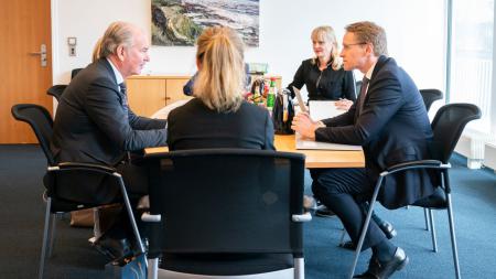 Ministerpräsident Günther und der schwedische Botschafter sitzen gemeinsam am Tisch und unterhalten sich. 