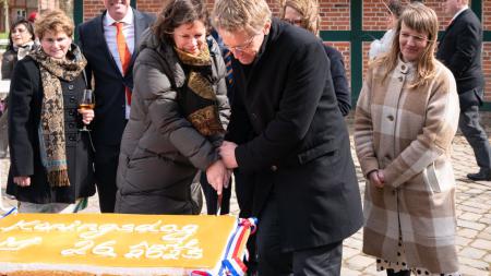 Ministerpräsident Günther und Landtagspräsidentin Herbst schneiden zum Konigsdag 2023 gemeinsam einen großen Blechkuchen an. 