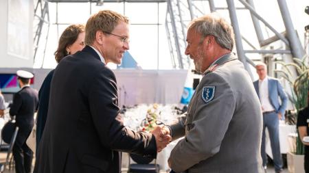 Ministerpräsident Daniel Günther schüttelt einem Mann des Sanitätsdienstes der Bundeswehr die Hand.