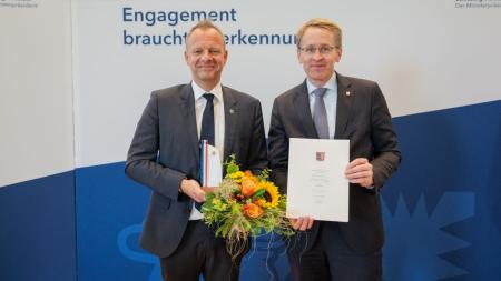 Ministerpräsident Daniel Günther überreichte die Auszeichnung an den Vereinsvorsitzenden, Dr. Hauke Berndt.