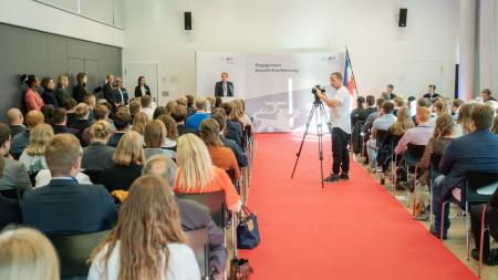 Ministerpräsident Daniel Günther hält eine Rede vor einem Raum voller ehrenamtlich engagierter Jugendliche. 