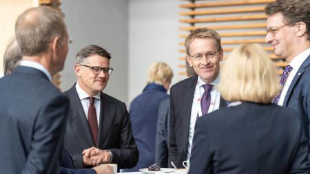 Ministerpräsident Daniel Günther im Gespräch mit mehreren Amtkolleginnen und -kollegen bei der MPK, darunter Boris Rhein und Hendrik Wüst.