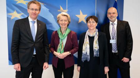 Ministerpräsident Günther, EU-Kommissionspräsidentin von der Leyen, Finanzministerin Heinold und Thorsten Augustin, Leiter des Hanse-Office in Brüssel, stehen gemeinsam vor einer Wand mit aufgedruckter EU-Flagge und lächeln in die Kamera.