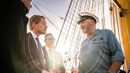 Ministerpräsident Daniel Günther und Gorch Fock-Kapitän Nils Brandt an Deck des Segelschiffes.