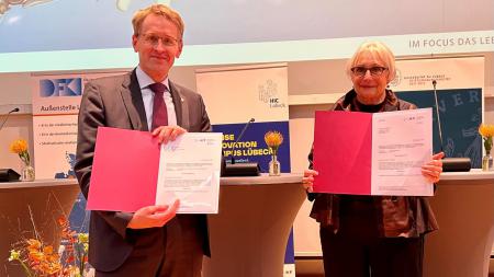 Ministerpräsident Daniel Günther und Professorin Dr. Gabriele Gillessen-Kaesbach stehen auf einer Bühne.