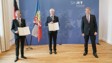 Lutz Hennings (v.l.), Diethard Tautz und Ministerpräsident Daniel Günther bei der Ehrung in Kiel.